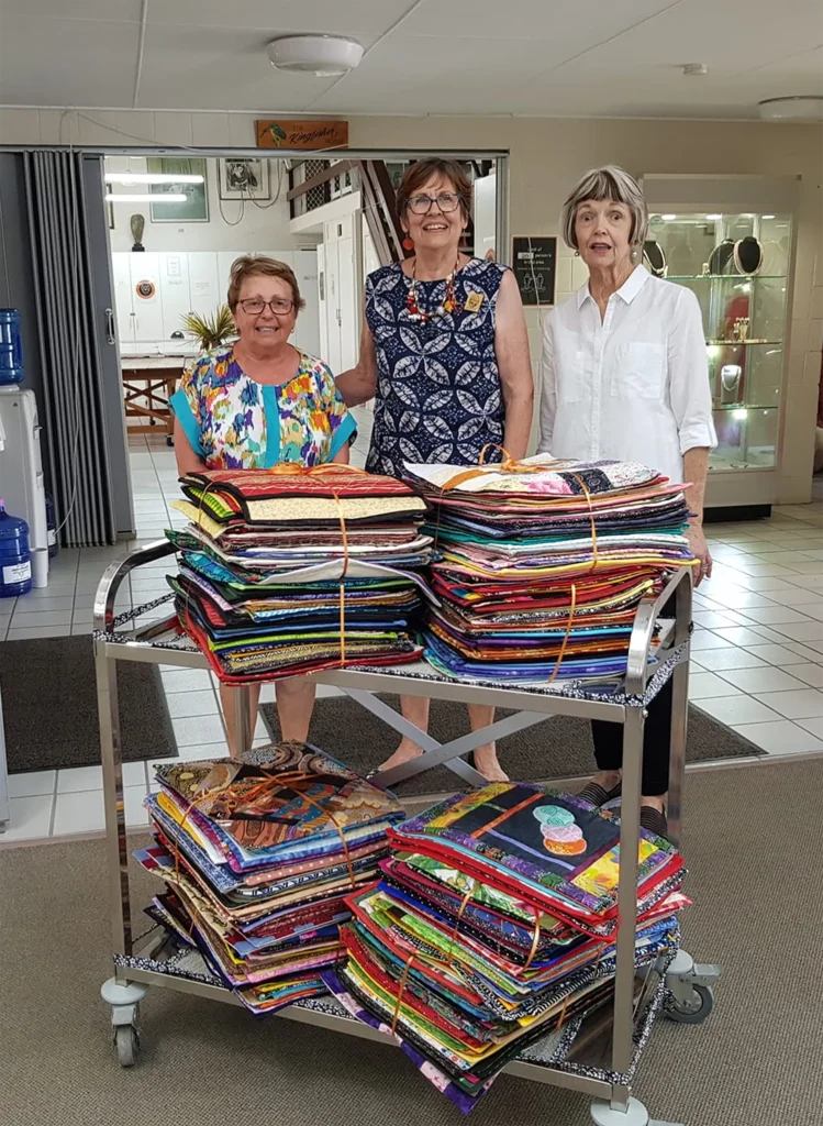 Members of the Caloundra Quilters group at Caloundra Arts Centre Association making a donation of quilts.