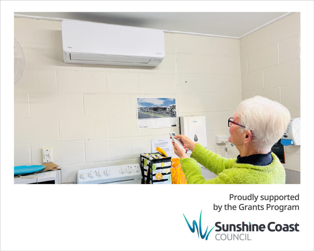 A member of Caloundra Arts Centre Association turns on the new airconditioning unit, installed thanks to a Sunshine Coast Council grant.